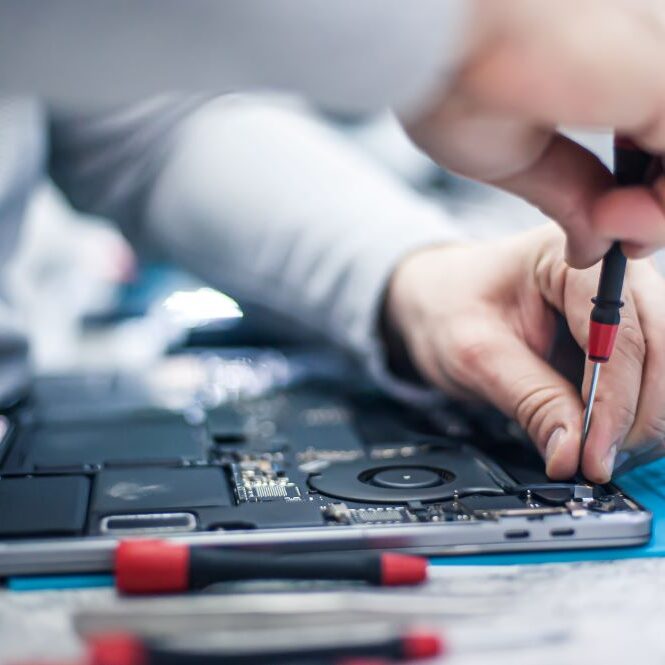 A professional computer repair service member repairing an apple computer.