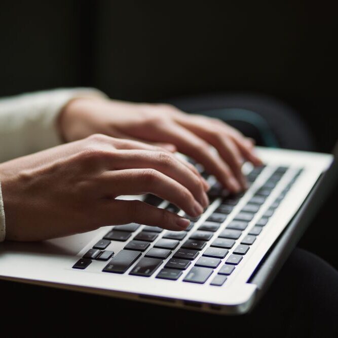 A person completing working on an Apple laptop.