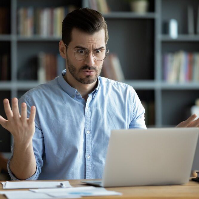 A man with a confused expression after his computer crashes unexpectedly.