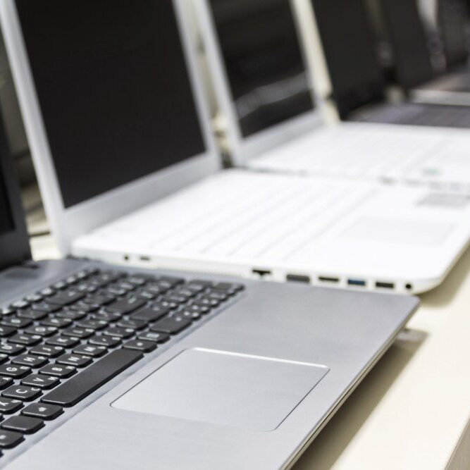 A row of laptop trade-ins at a computer store.